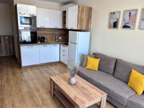 a living room with a couch and a table and a kitchen at Апартаменти Bella Deluxe in Ravda