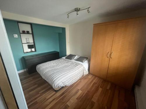 - une chambre avec un lit et une armoire en bois dans l'établissement Appartement condo dans le vieux Québec, à Québec