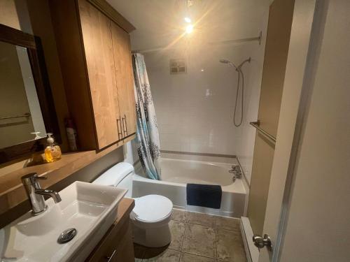 La salle de bains est pourvue d'un lavabo, de toilettes et d'une baignoire. dans l'établissement Appartement condo dans le vieux Québec, à Québec