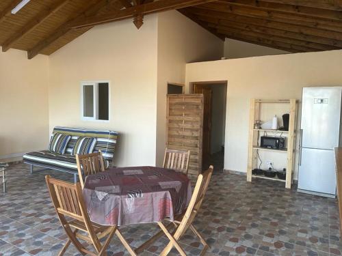 a room with a table and chairs and a refrigerator at Dependance Sainte Marguerite in Le Moule
