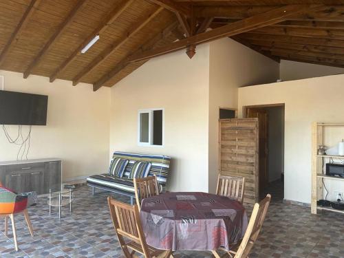 a room with a table and chairs and a couch at Dependance Sainte Marguerite in Le Moule