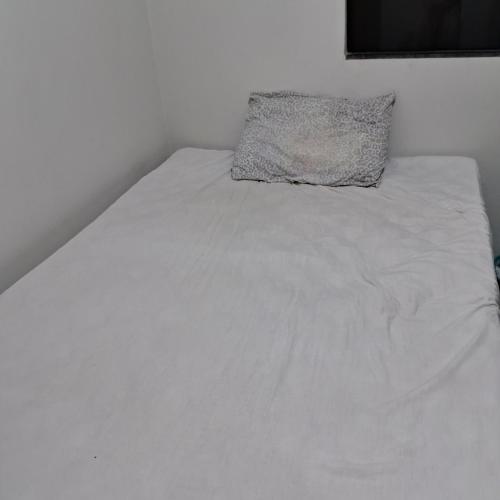 Una cama blanca con una almohada encima. en Recanto Nascente do Segredo, en Campo Grande