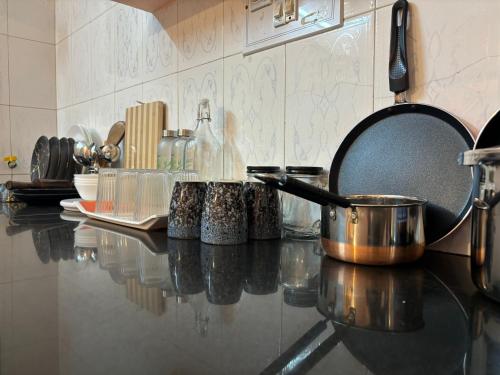 a kitchen counter with pots and pans on it at Ka'vi in Dāvangere
