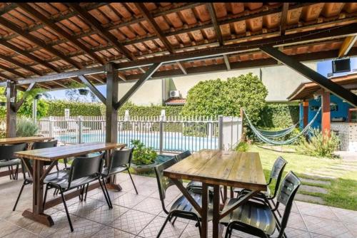 a patio with wooden tables and chairs and a hammock at POUSADA LOS AMIGOS CAMPECHE in Florianópolis