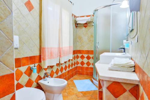 y baño con aseo, lavabo y ducha. en Nuraghe Bianco, en Santa Maria la Palma