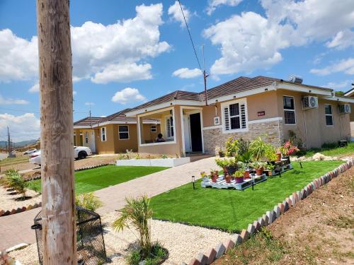 a house with a lawn in front of it at The Surada Bay 2 bedrooms in Old Harbour