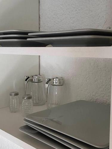 a refrigerator with glasses and a laptop on a shelf at Villa Entre Fresnos in Ciudad Lujan de Cuyo