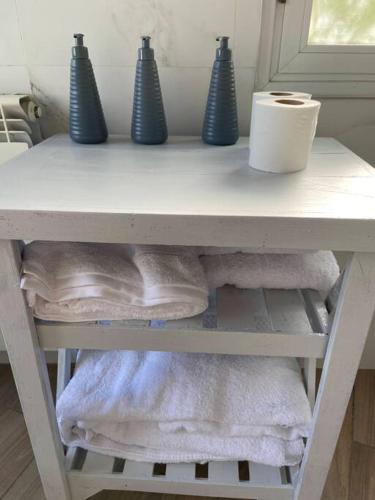 a white shelf with towels and blue vases on it at Villa Entre Fresnos in Ciudad Lujan de Cuyo
