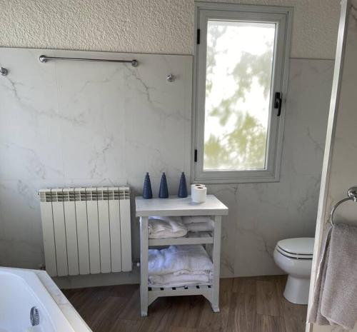 a bathroom with a sink and a toilet and a window at Villa Entre Fresnos in Ciudad Lujan de Cuyo