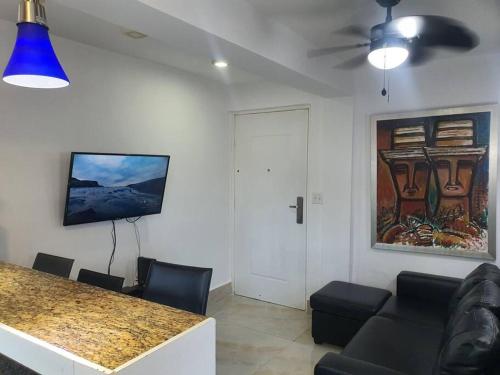 a living room with a table and chairs and a painting at 55-7 Lindo y céntrico apto. in Panama City