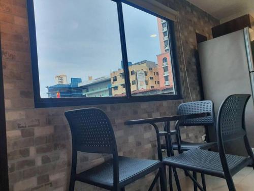 a table and chairs in a room with a window at 55-7 Lindo y céntrico apto. in Panama City