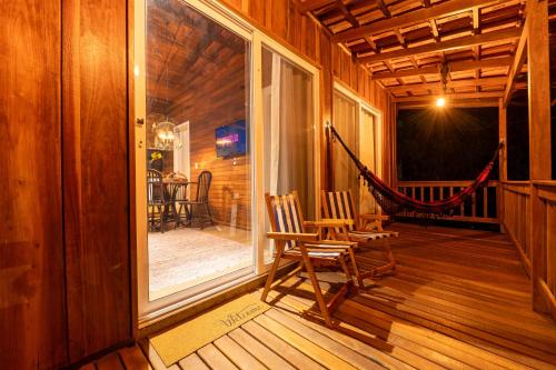 a porch with a hammock in a wooden house at Cabanas da Fazenda / 02 in Gramado