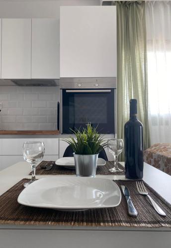 a table with a white plate and a bottle of wine at Gianna's house in Nikiti
