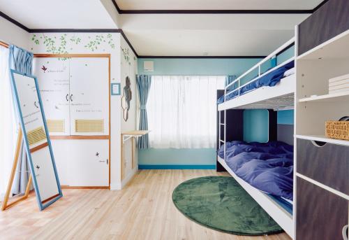 een slaapkamer met een stapelbed en een groen tapijt bij PEDAL TERRACE in Iida