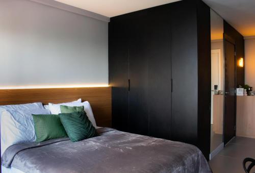 a bedroom with a large bed with green pillows at Studio Vila Madalena Mirant in São Paulo