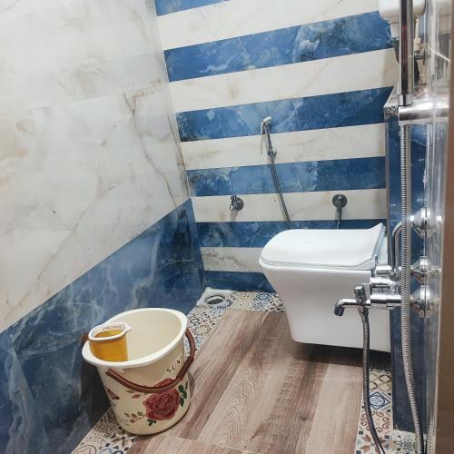 a bathroom with a white toilet and blue and white stripes at Maha Periyava Kuteeram in Kumbakonam