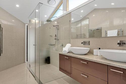 a bathroom with two sinks and a glass shower at Las Palmas in Gold Coast