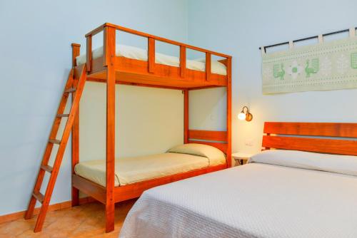 een slaapkamer met 2 stapelbedden en een ladder bij Nuraghe Bianco in Santa Maria la Palma