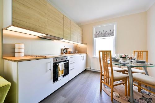 a kitchen with a table and a dining room at A two bedroom a stride away from Meridian Greenwich in London