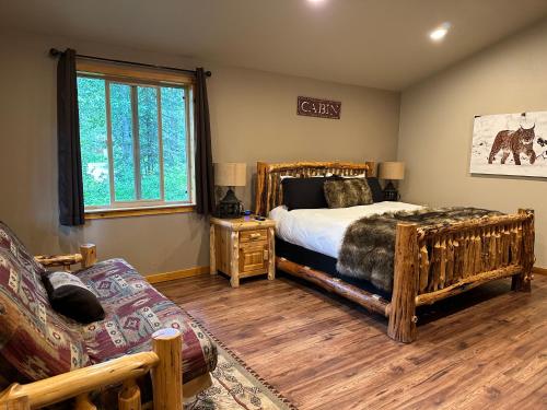 a bedroom with a bed and a couch and a window at Summit Lake Lodge in Summit Lake