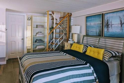 a bedroom with a bed with yellow pillows and a ladder at Un havre de paix! in Saint Adolphe D'Howard