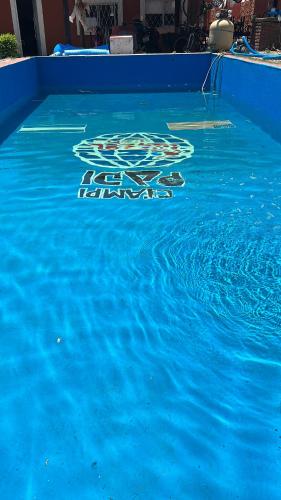 a pool of blue water with a not swimming sign on it at Casa in Tristán Suárez