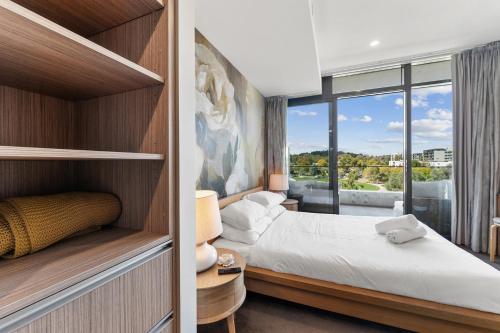 a bedroom with a bed and a large window at Stylish 2-Bed with Amenities 10-Min from CBD in Campbell