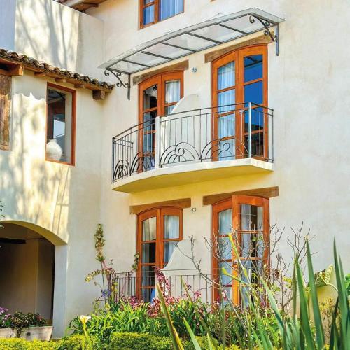an apartment building with a balcony and plants at Hotel Junvay in San Cristóbal de Las Casas