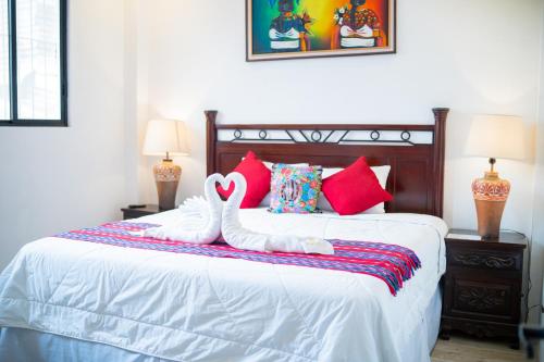 two swans sitting on top of a bed at Hotel Taa' Tiin in San Juan La Laguna