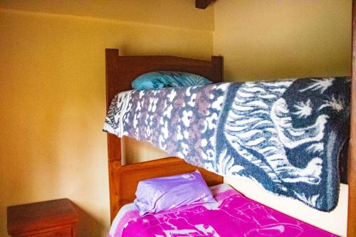 a bunk bed with a tiger patterned blanket on it at Hostal El Inca in Chucchilán