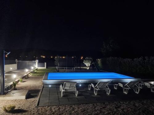 een zwembad 's nachts met een groep stoelen bij Family friendly house with a swimming pool Sestanovac, Zagora - 22984 in Šestanovac