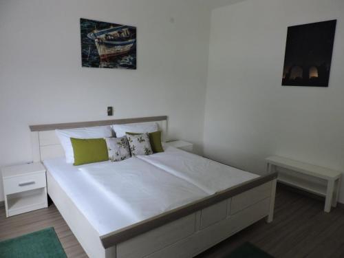 een slaapkamer met een groot wit bed met groene kussens bij Family friendly house with a swimming pool Sestanovac, Zagora - 22984 in Šestanovac