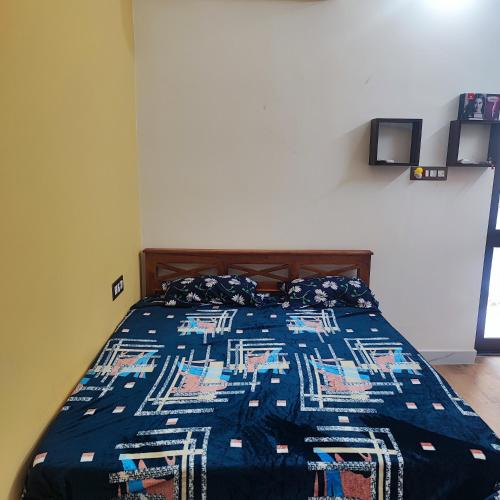 a bedroom with a bed with a blue comforter at Maha Periyava Kuteeram in Kumbakonam