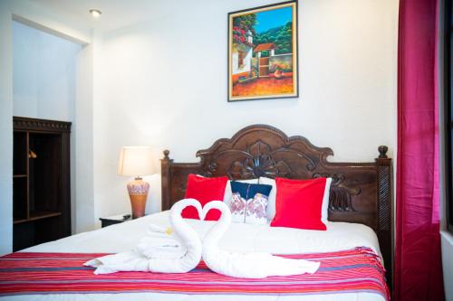 two swans made out of towels sitting on a bed at Hotel Taa' Tiin in San Juan La Laguna