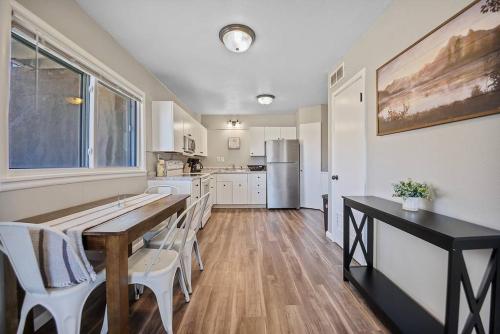 a kitchen with a wooden table and white chairs at Downtown Condo-Lower Level in Rapid City