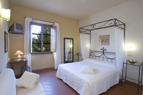 a bedroom with a white bed and a window at Hotel Scilla in Sovana