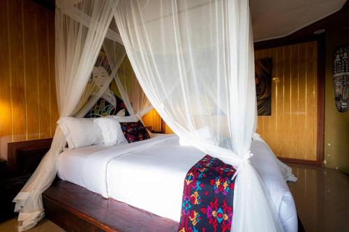 - une chambre avec un lit à baldaquin et des rideaux blancs dans l'établissement Family Room 2 With Sharing Pool, à Silebeng