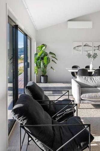 a living room with couches and a table and chairs at Kinloch Bach with heaps of room! in Kinloch