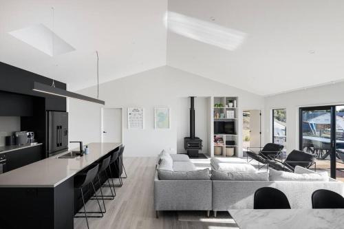 a kitchen and living room with a couch and a table at Kinloch Bach with heaps of room! in Kinloch