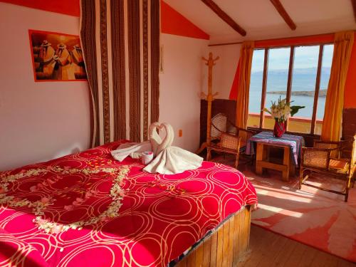 Inti kala lodge في Comunidad Yumani: غرفة نوم بسرير ولحاف احمر