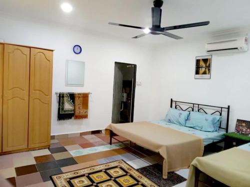 Kampong Alor Gajah的住宿－D Anjung Homestay Aisy，一间卧室配有一张床和吊扇