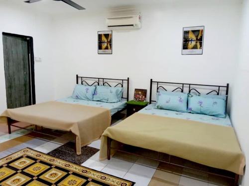 Kampong Alor Gajah的住宿－D Anjung Homestay Aisy，一间客房内配有两张床的房间