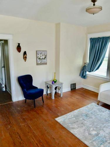 a living room with a blue chair and a table at Keur Koura in The Ville in Saint Louis
