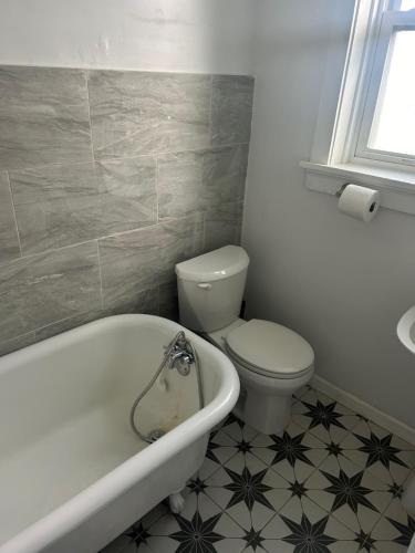 a bathroom with a toilet and a tub and a sink at Keur Koura in The Ville in Saint Louis