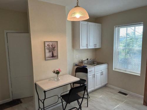 a kitchen with a table and two chairs and a sink at Keur Koura @The Ville in Saint Louis