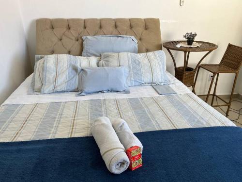 a large bed with two rolled up towels on it at Apartamento Salvador/200m da praia. in Salvador