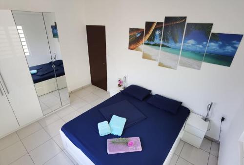 Una habitación con una cama azul con dos cajas. en Roadrunner-Bonaire, en Kralendijk