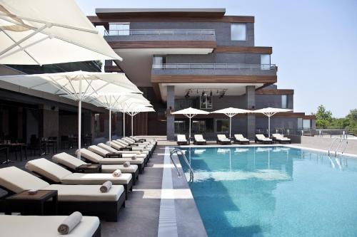 a hotel with a pool with lounge chairs and umbrellas at Divan Bursa in Bursa