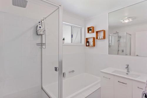 een witte badkamer met een douche en een wastafel bij The Shack Port Elliot - Wi-Fi - Family - BYO Linen in Port Elliot