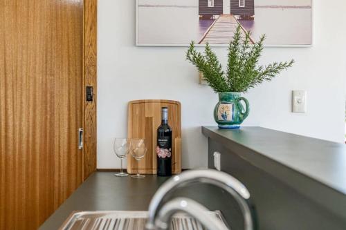 a sink with a bottle of wine and two wine glasses at 11 Elizabeth - BYO Linen - Ocean Glimpses in Middleton